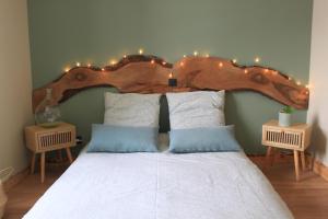 - une chambre avec un grand lit et une tête de lit en bois dans l'établissement Belladone Guest House theys Les 7 Laux, à Theys