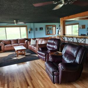 uma sala de estar com sofás de couro e uma mesa em Lakeviewlanding em Big Arm