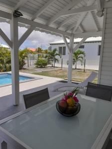 a bowl of fruit sitting on a table on a patio at Gîtes de Corneille, Bungalow Little Banania in Le Moule