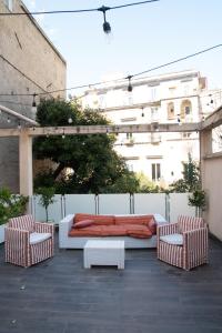 a bed and two chairs on a patio at Regina Margherita Suite in Naples