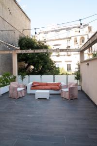 - une terrasse avec deux chaises, un lit et une table dans l'établissement Regina Margherita Suite, à Naples