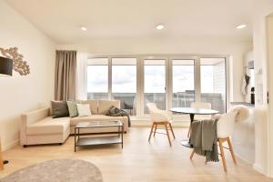 a living room with a couch and a table at Strandperle Ostsee Suite 3 in Niendorf