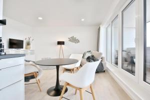 a kitchen and living room with a table and chairs at Strandperle Ostsee Suite 3 in Niendorf
