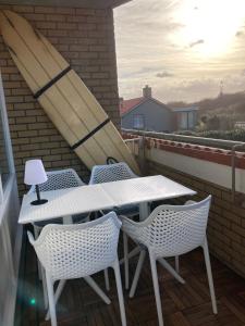 a white table and chairs on a balcony at CallantsDuinzicht, Beachappartement 24 in Callantsoog