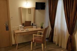 アテネにあるアイロテル パルテノンのデスク、椅子、鏡が備わる客室です。