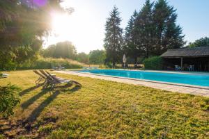 un banc installé dans l'herbe à côté d'une piscine dans l'établissement Château Le Boisrenault, à Buzançais