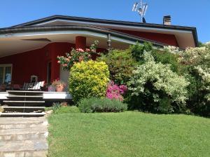 una casa con dei cespugli e dei fiori di fronte di 'L SASS a Borgomanero