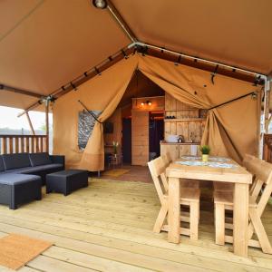 a tent with a table and chairs in it at Baza Maciejòwka in Międzywodzie