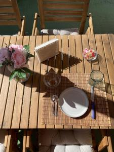 a wooden table with a plate and flowers on it at Smit House in Torre dell'Orso