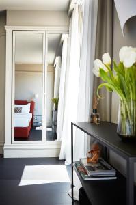 un soggiorno con specchio e divano rosso di HOTEL VITE - By Naman Hotellerie a Roma