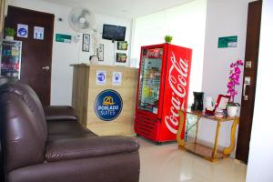 a coca cola machine and a chair in a room at Hotel Poblado Suite in Barranquilla