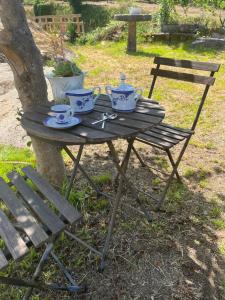 a picnic table with tea sets on it next to a tree at Casa Las Piedras in Padrenda