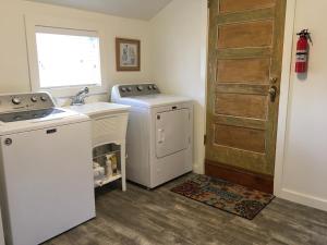 a kitchen with a washer and a sink and a door at Adorable Home on the Park 10 Miles South of Eugene in Creswell