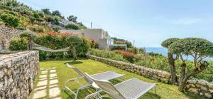 dwa krzesła i hamak w ogrodzie z widokiem na ocean w obiekcie Villa DAlessandro w mieście Anacapri +37 zdjęć