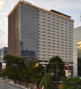 a tall building with many windows on a city street at D'Vanaest in Semarang