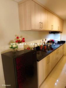 a kitchen with a black refrigerator and wooden cabinets at D'Vanaest in Semarang