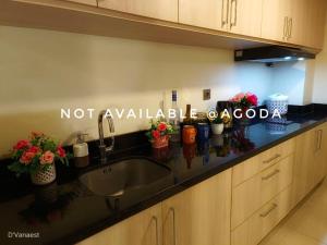 a kitchen counter with a sink and flowers on it at D'Vanaest in Semarang +5 photos