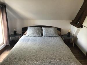 1 dormitorio con 1 cama grande y 2 mesas en Maison De ville Bayeux, en Bayeux