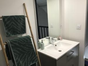 a bathroom with a sink and a mirror and a towel at Maison De ville Bayeux in Bayeux