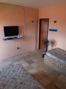 a room with a wall with a flat screen tv at Flat Casa Taiba 2001 in Taíba