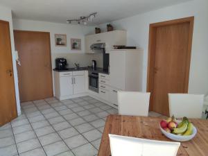 a kitchen with a table with a bowl of fruit on it at Ferienwohnung am Trillenbühl in Salem