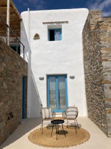 two chairs and a table in front of a white building at Sun House Paros in Kampos Paros
