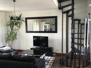 a living room with a black couch and a television at Maison De ville Bayeux in Bayeux +10 photos