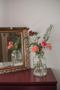 a vase of flowers on a table next to a mirror at Gallery Apartment 2 in Martin
