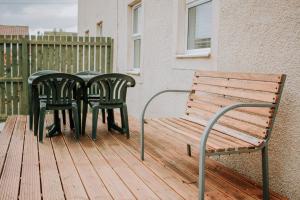 two chairs and a table and a bench on a deck at The Bailey - Troon - Coorie Doon Stays in Troon