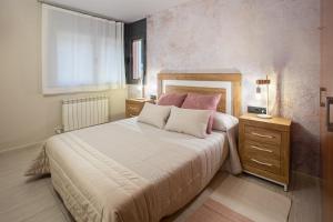 a bedroom with a large bed with pink pillows at El Catllar in Ripoll