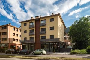 un edificio con coches estacionados frente a él en El Catllar, en Ripoll