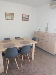 una mesa de madera con sillas y un armario en una habitación en Apartament Edifici Simbat a 150m de la platja, en Palamós
