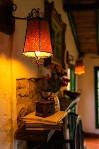una lámpara en una mesa con libros en ella en Estancia San Antonio en Guasca