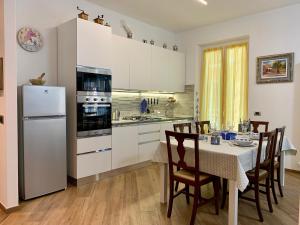 a kitchen with a table and a white refrigerator at La Casa dei Nonni in Levanto