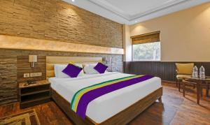 钱德加尔Treebo Premium Arista的一间卧室，里面有一张大床和一张桌子。