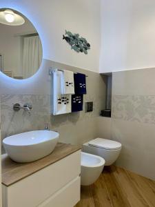 a bathroom with a sink and a toilet and a mirror at La Casa dei Nonni in Levanto +13 photos