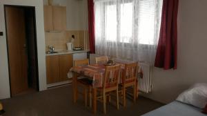 eine Küche mit einem Tisch und Stühlen sowie einem Fenster in der Unterkunft Apartmany U Ády in Železná Ruda