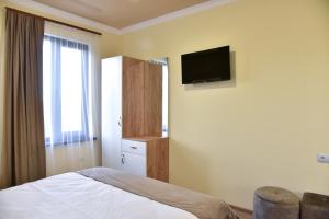 a bedroom with a bed and a tv on the wall at ABA Resort in Gyulagarak
