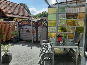 a patio with a table and chairs and a fence at Ferienwohnung Alte Glaserei in Ilsenburg