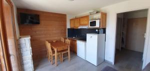 a small kitchen with a table and a microwave at Appartement 3 étoiles 6 personnes les Orres 1800 in Les Orres