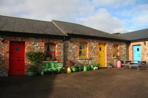 a brick building with a red door and a bench at Slane Farm Hostel, Cottages and Camping in Slane