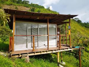 ein winziges Haus auf einer Plattform mit einem Hügel im Hintergrund in der Unterkunft Glamping Adrenalina Extrema in San Agustín