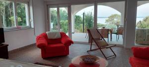 un salon avec une chaise rouge et une table dans l'établissement Apartman Ivan, à Mandre