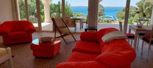 un salon avec un canapé rouge et des chaises dans l'établissement Apartman Ivan, à Mandre