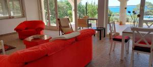 - un salon avec des canapés rouges, une table et des chaises dans l'établissement Apartman Ivan, à Mandre