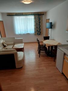 JOHN’S MOTEL APPARTEMENTHAUS في Attnang-Puchheim: غرفة معيشة مع أريكة وطاولة