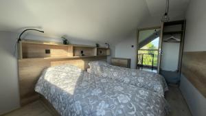 a bedroom with a bed and a large window at Domek na Roztoczu Obrocz 73C z SAUNĄ in Zwierzyniec +51 photos