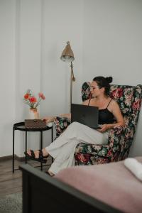 a woman sitting on a couch with a laptop at Gallery Apartment 3 in Martin