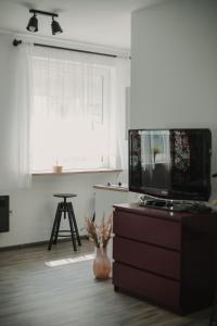 a living room with a tv on a dresser and a window at Gallery Apartment 3 in Martin