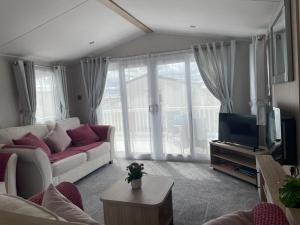 a living room with a couch and a tv at Dune View Caravan in Lossiemouth